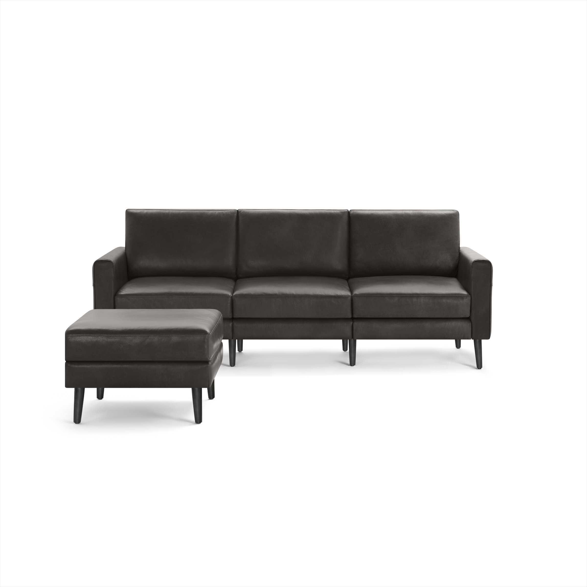 Modern dark gray leather sectional sofa with three seat cushions and matching ottoman, both featuring tapered wooden legs.