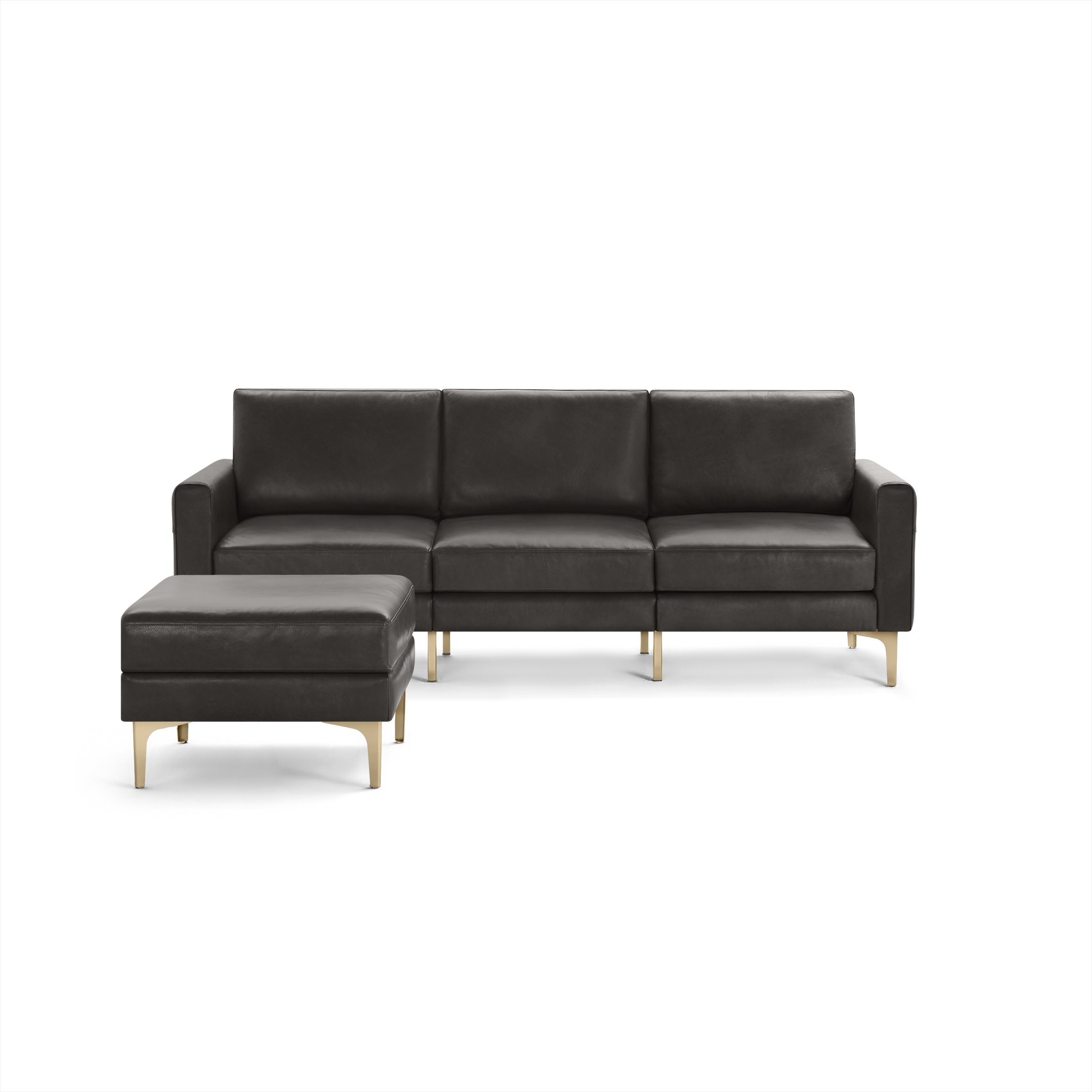 Modern dark gray leather sectional sofa with a matching ottoman, supported by sleek light-colored wooden legs.