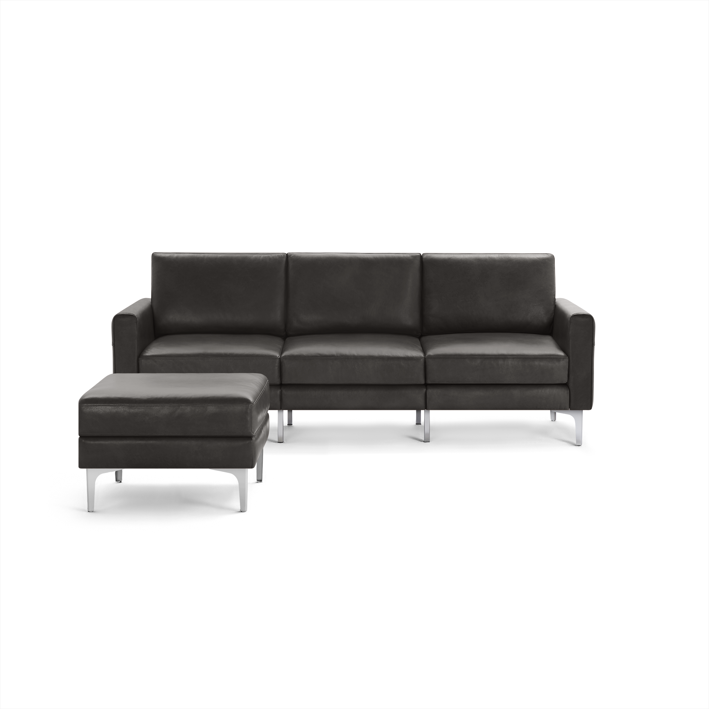 Dark gray leather three-seater sofa with matching ottoman, featuring sleek silver metal legs and modern design.