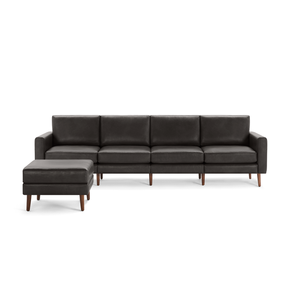 Modern dark gray leather sectional sofa with wooden legs and matching ottoman on the left side, sleek and minimalist design.