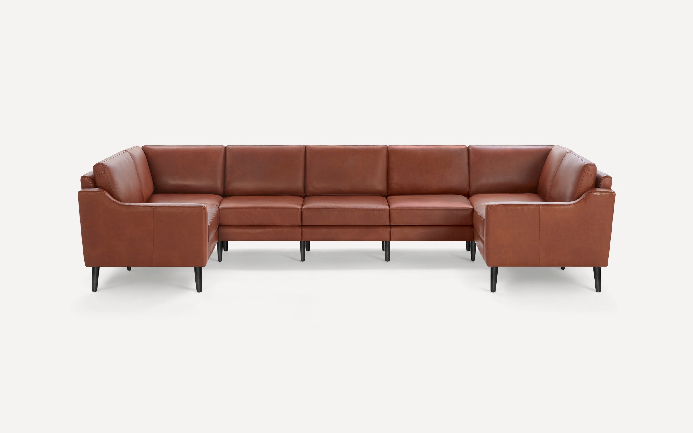 Large sectional sofa in brown leather with black tapered legs, featuring clean lines and modern design.