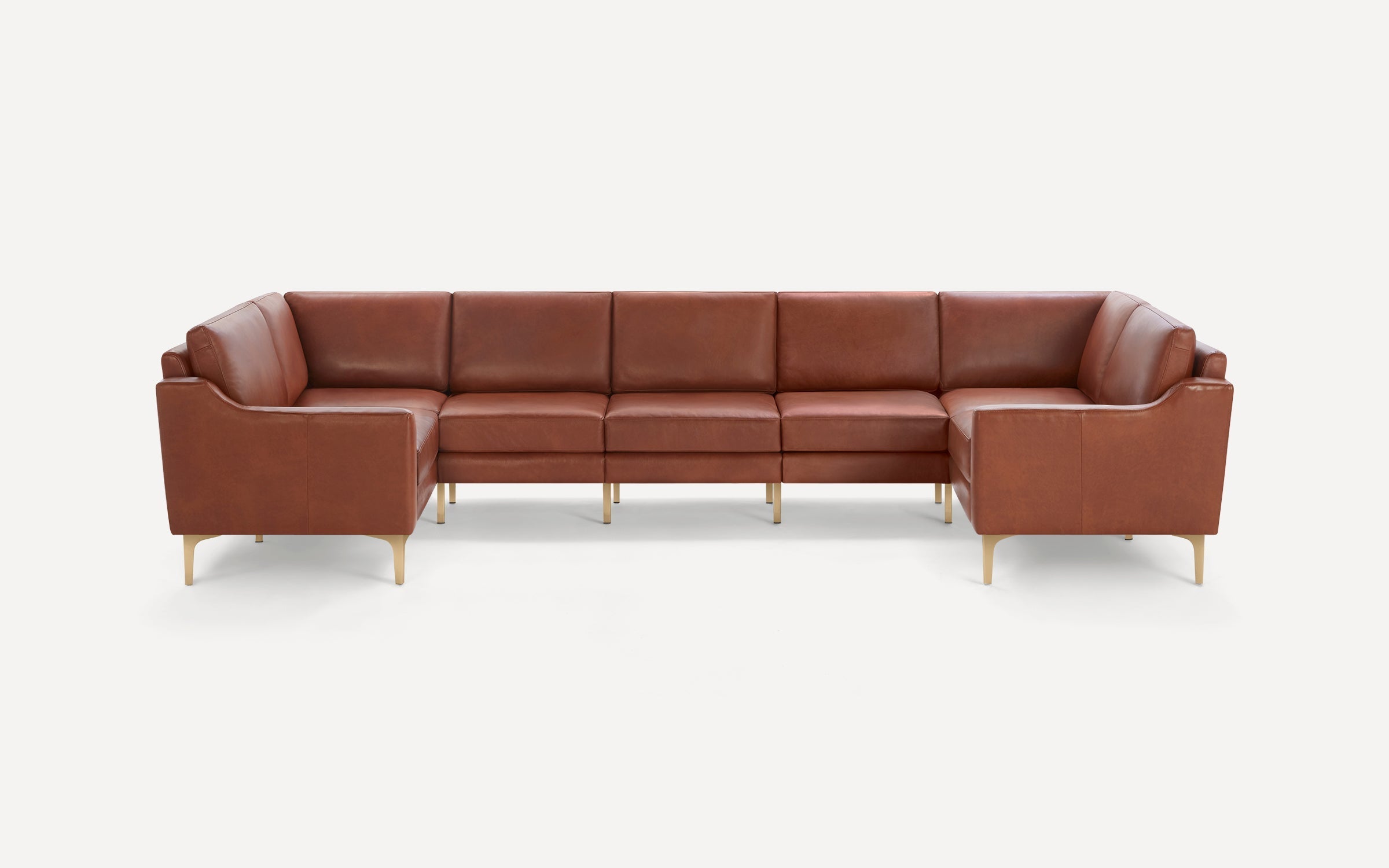 Large brown leather sectional sofa with gold metal legs, featuring clean lines and cushioned seats and backs.