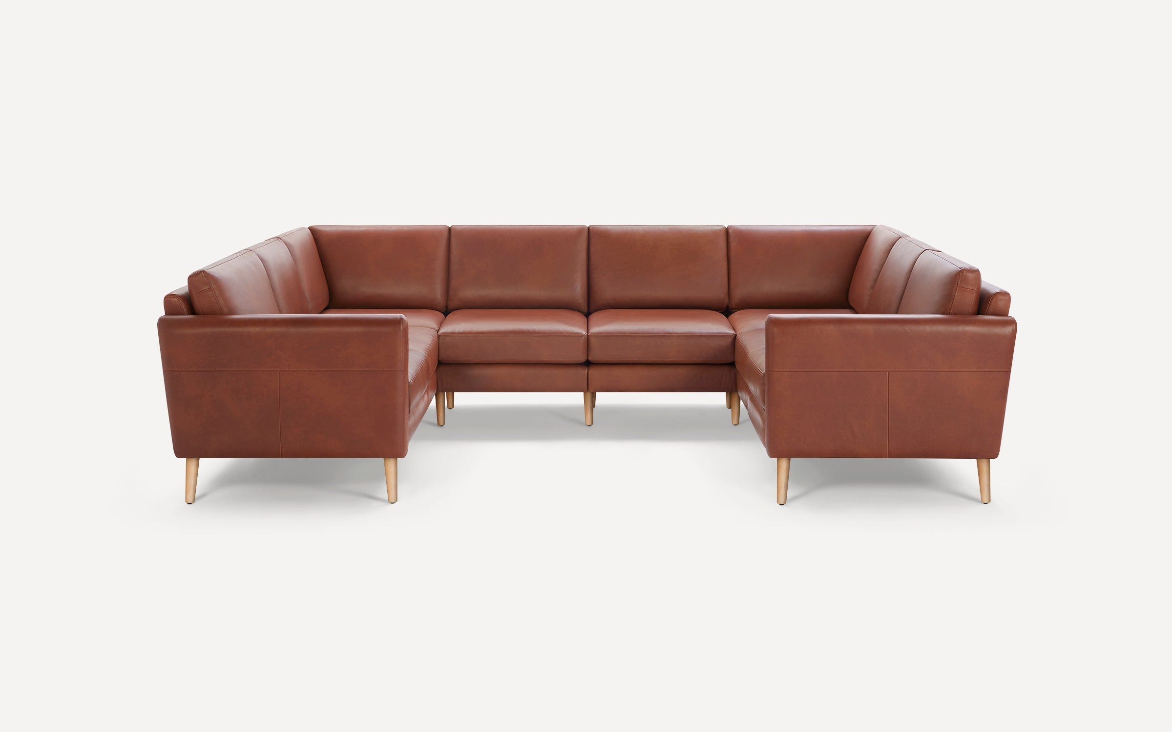 Brown leather U-shaped sectional sofa with wooden legs, featuring clean lines and cushioned seats and backrests.