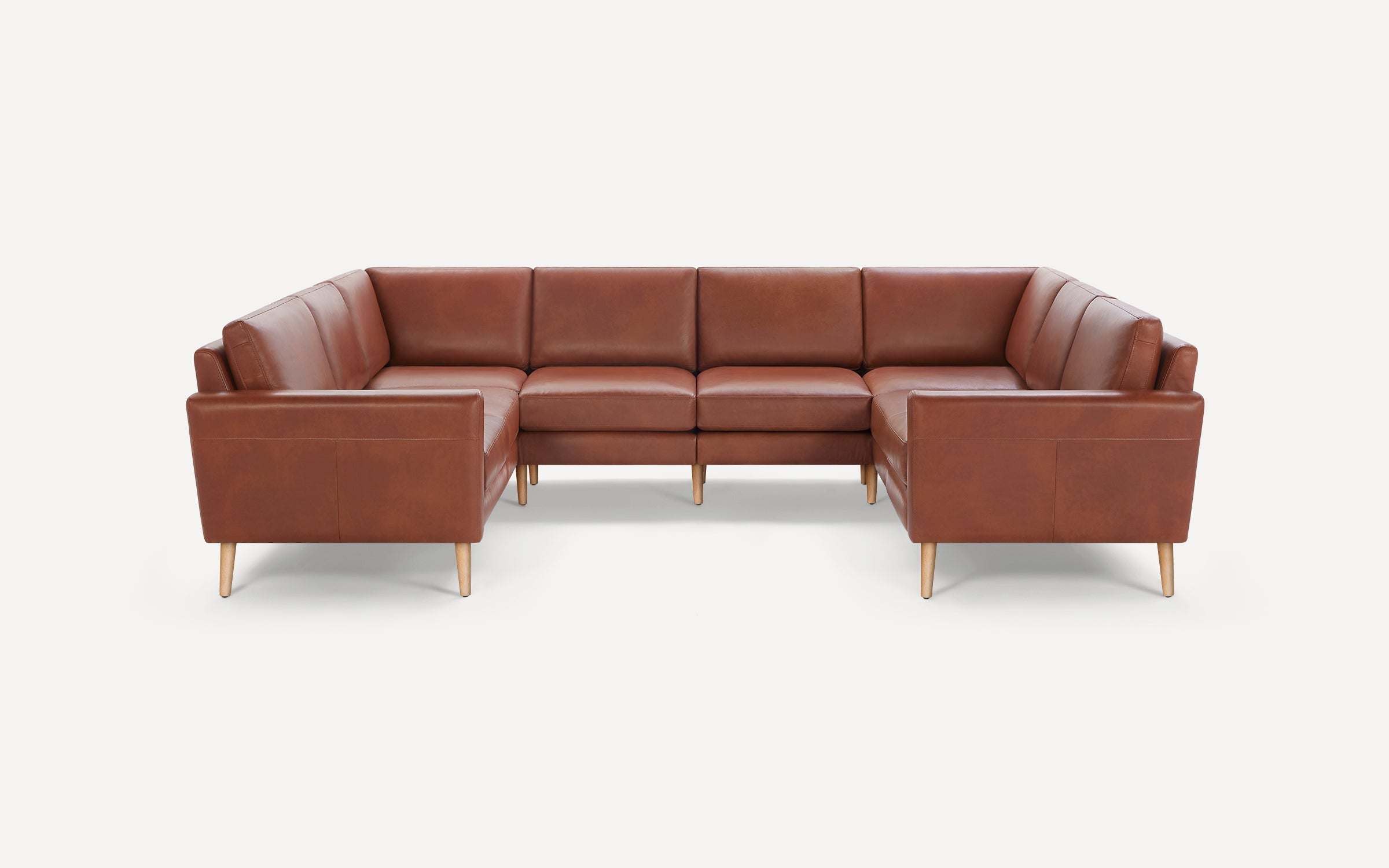 Brown leather upholstered L-shaped sectional sofa with wooden legs on a white background.