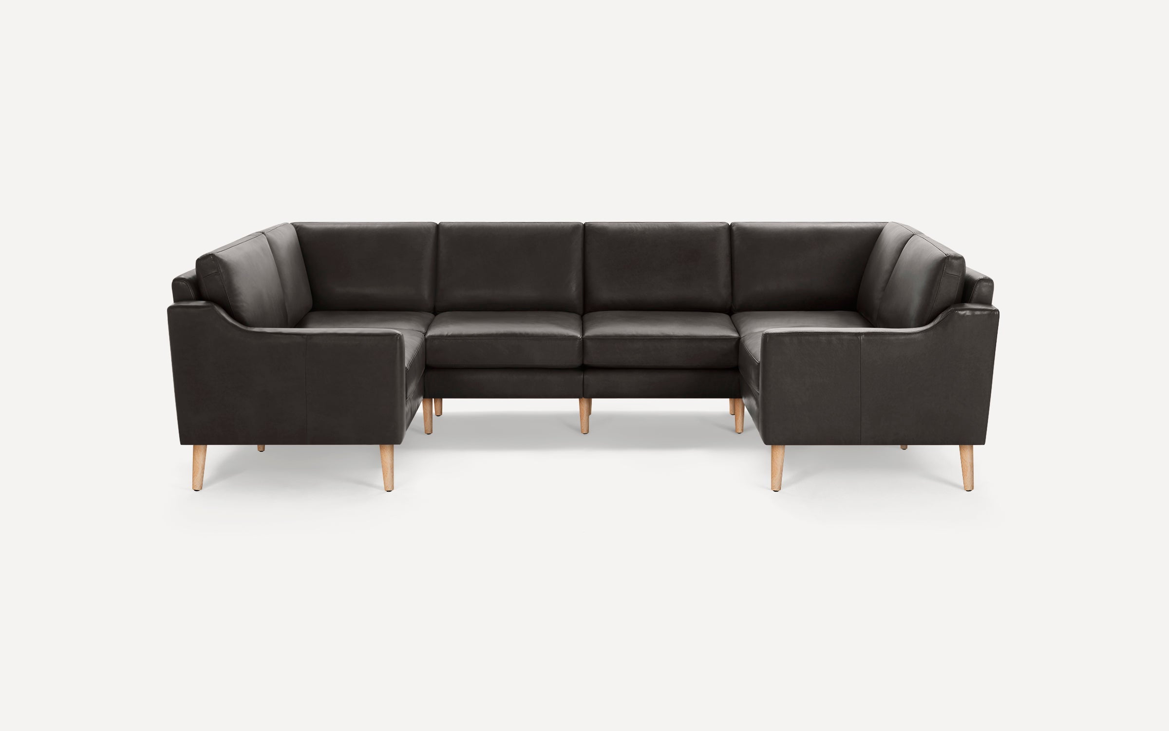 Modern dark gray leather sectional sofa with wooden tapered legs, featuring clean lines and plush cushioning.