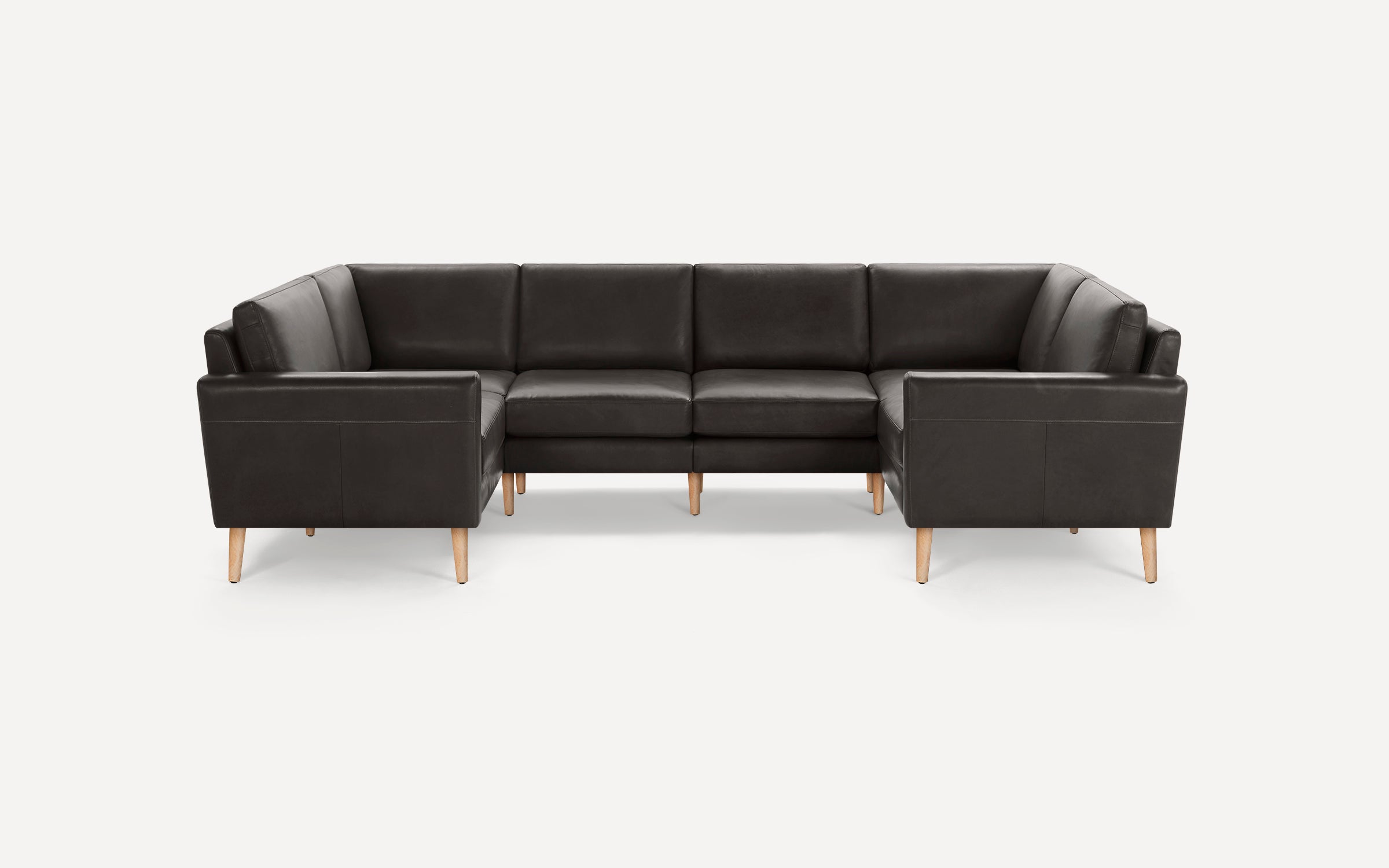 Dark brown leather sectional sofa with wooden legs, featuring straight arms and cushioned seats and backrests.