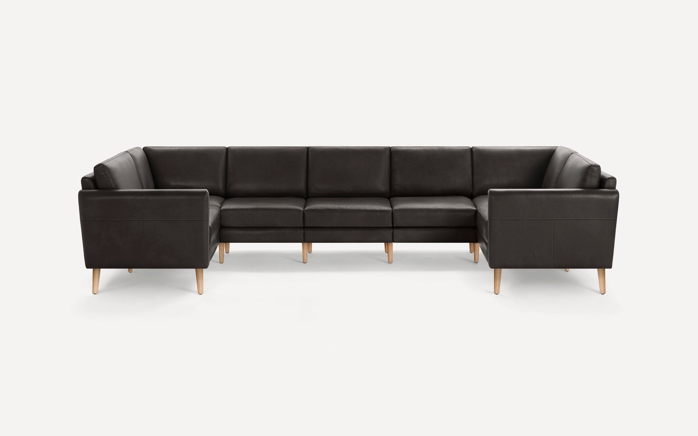 Modern dark brown leather sectional sofa with clean lines, cushioned seats, and light wooden legs on a white background.