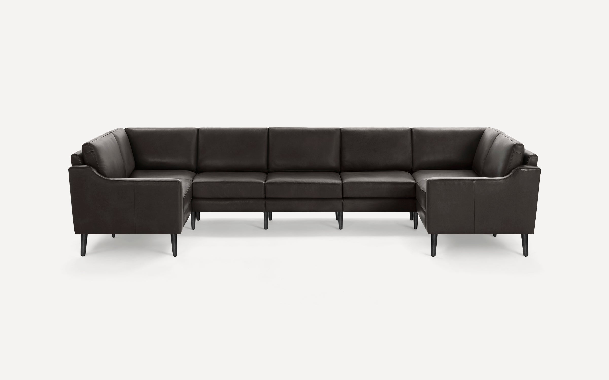 Modern black leather U-shaped sectional sofa with high backrests and slim black legs, designed for spacious seating.