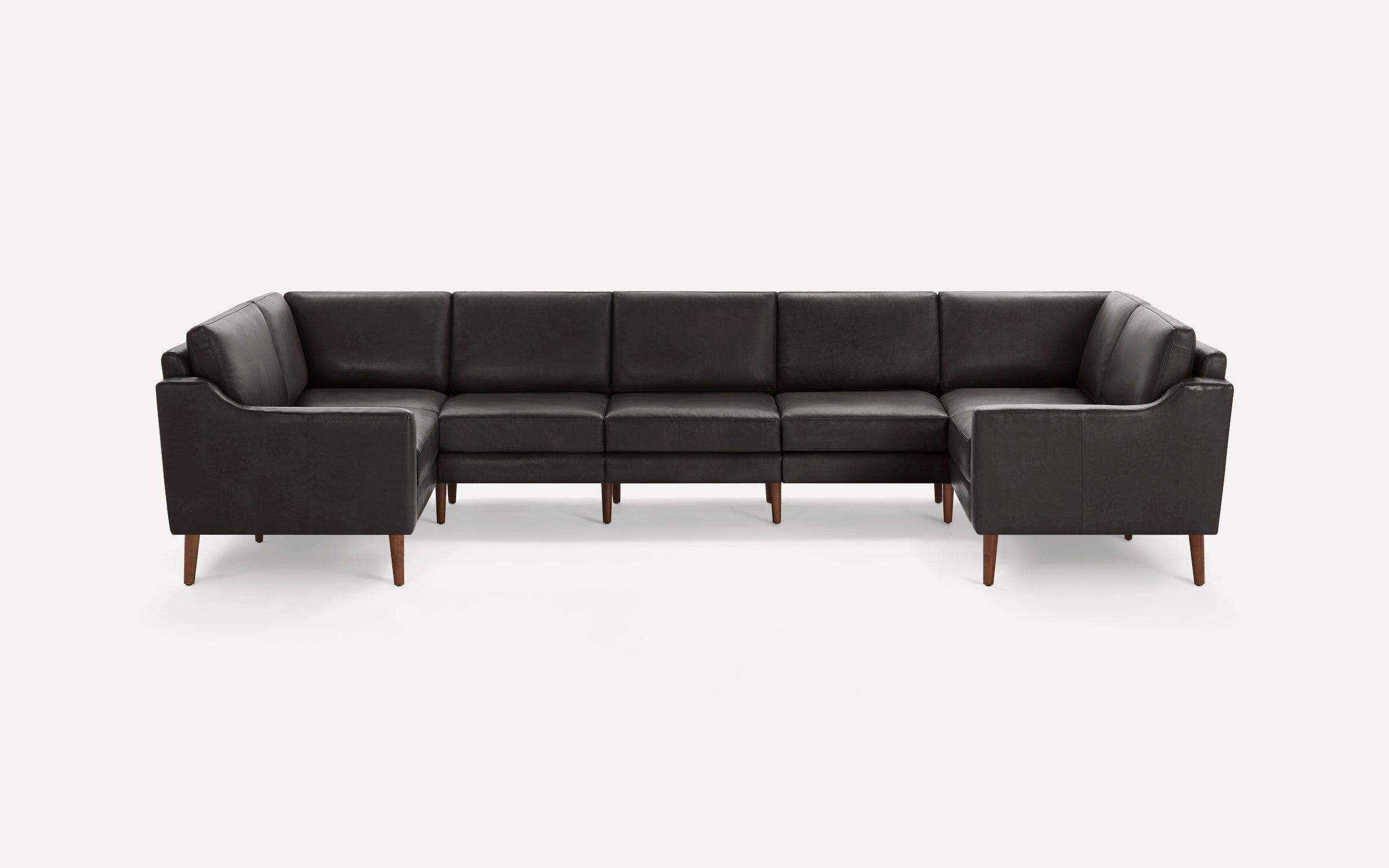 Large dark gray leather U-shaped sectional sofa with wooden legs, featuring clean lines and cushioned seats and backs.
