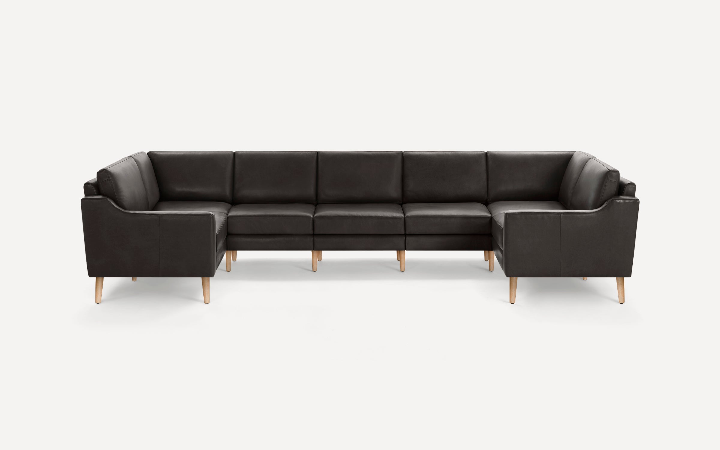 Large dark brown leather U-shaped sectional sofa with light wooden legs, clean lines, and modern design.