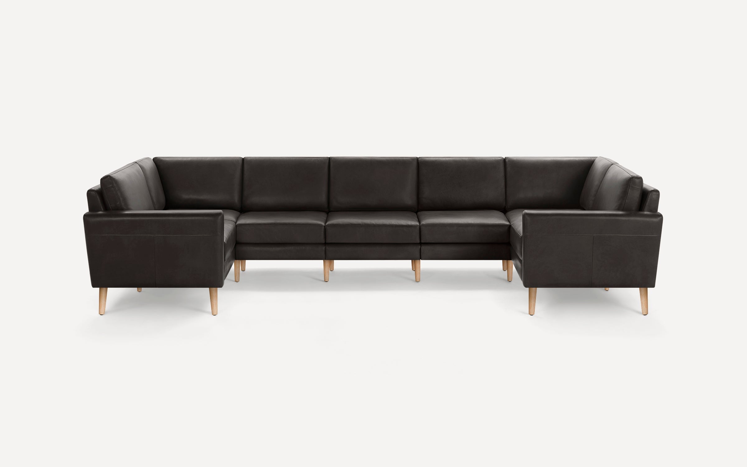 Large dark brown leather sectional sofa with clean lines and wooden tapered legs on a white background.