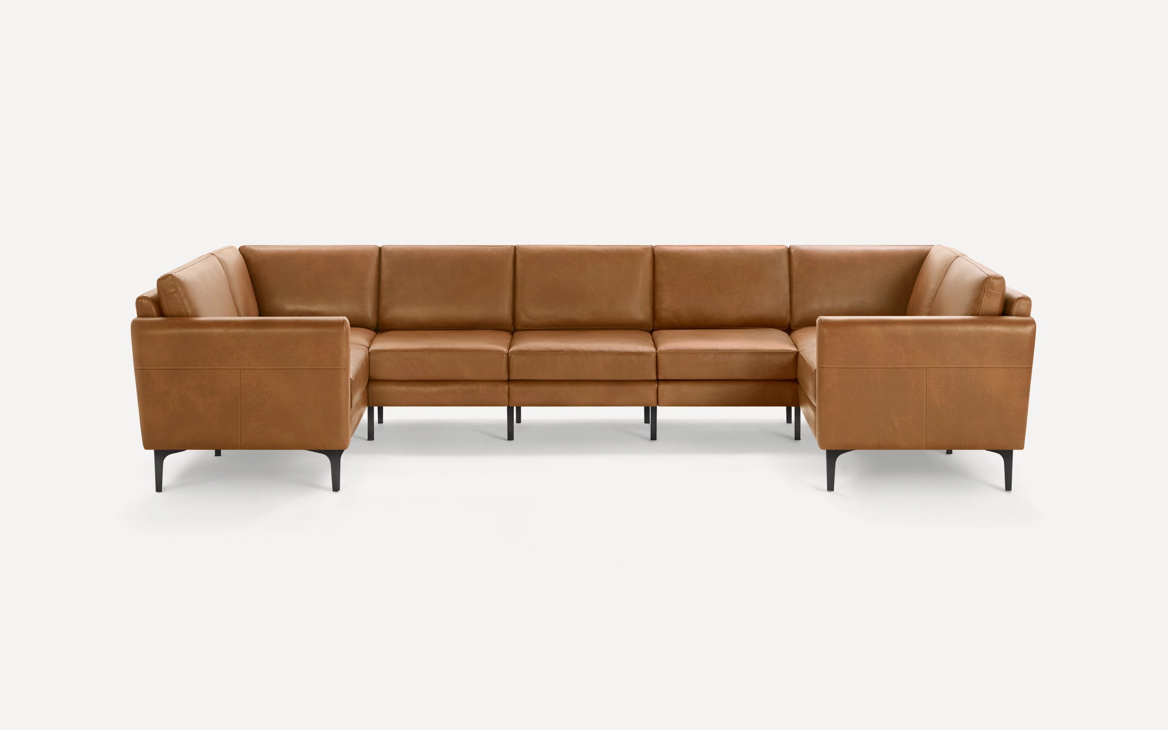Modern U-shaped sectional sofa upholstered in tan brown leather with slim black metal legs and clean lines.