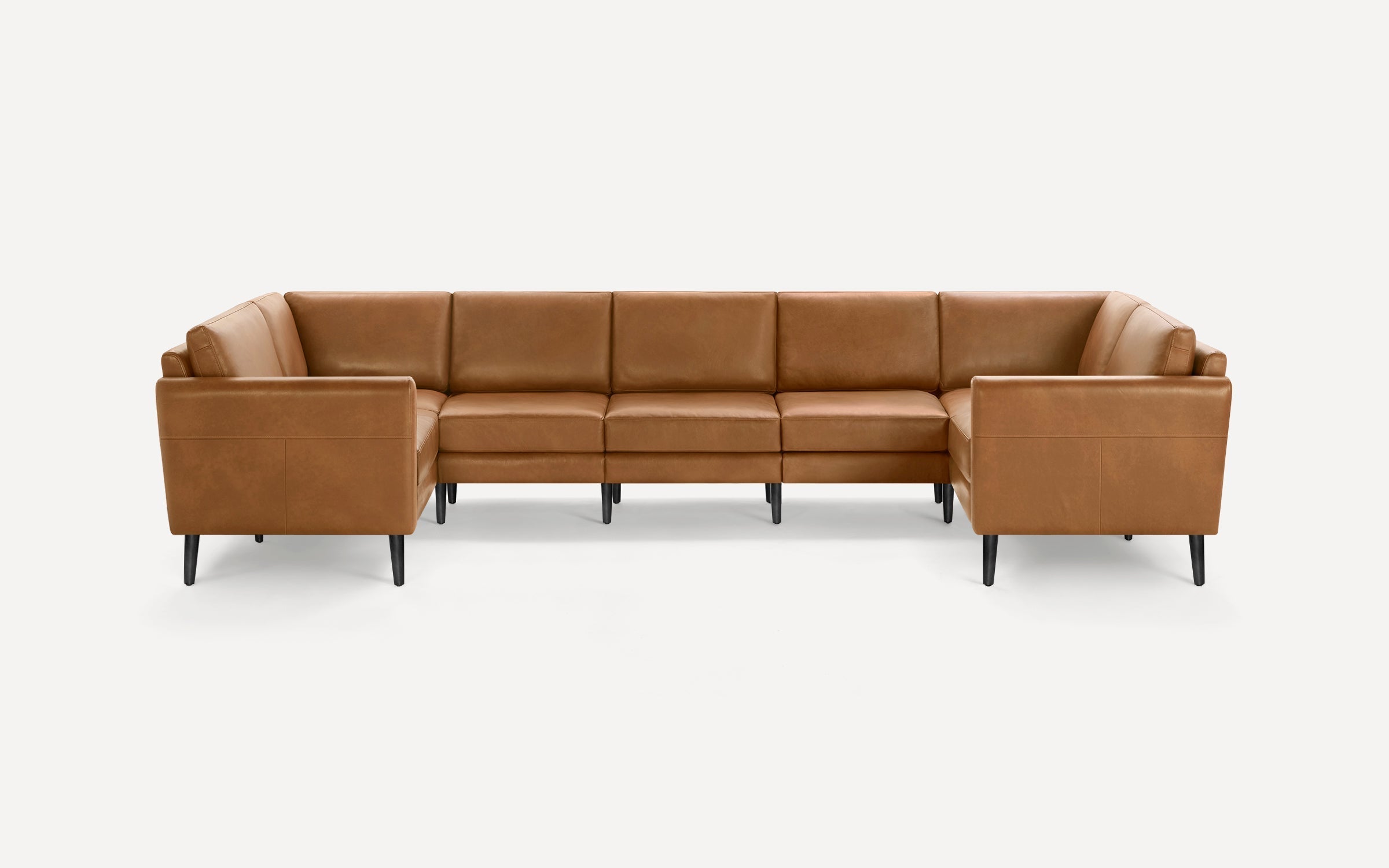 Brown leather U-shaped sectional sofa with clean lines, cushioned back and seats, and black tapered legs on a white background.