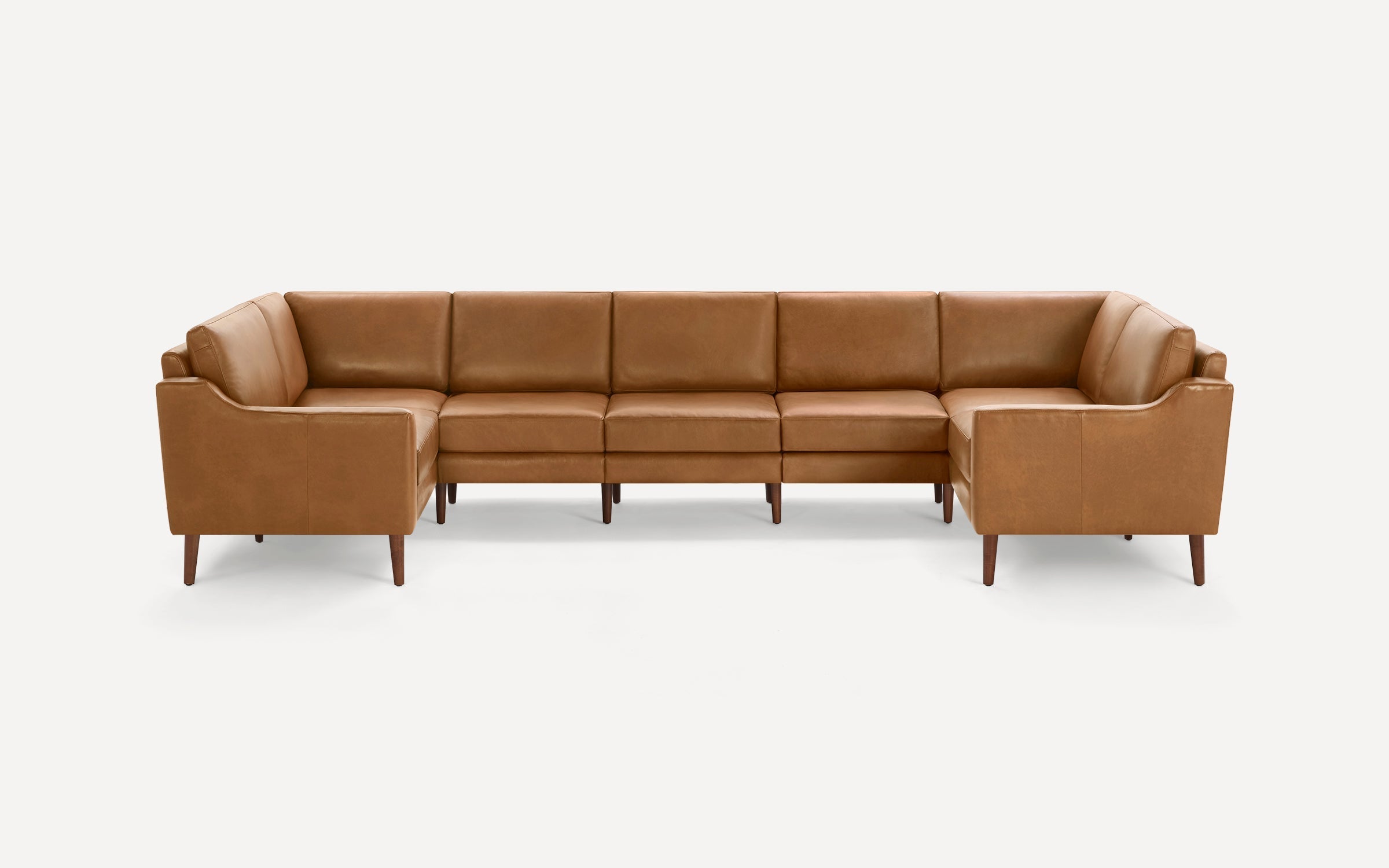 Large modern L-shaped sectional sofa upholstered in brown leather with wooden tapered legs and clean lines.