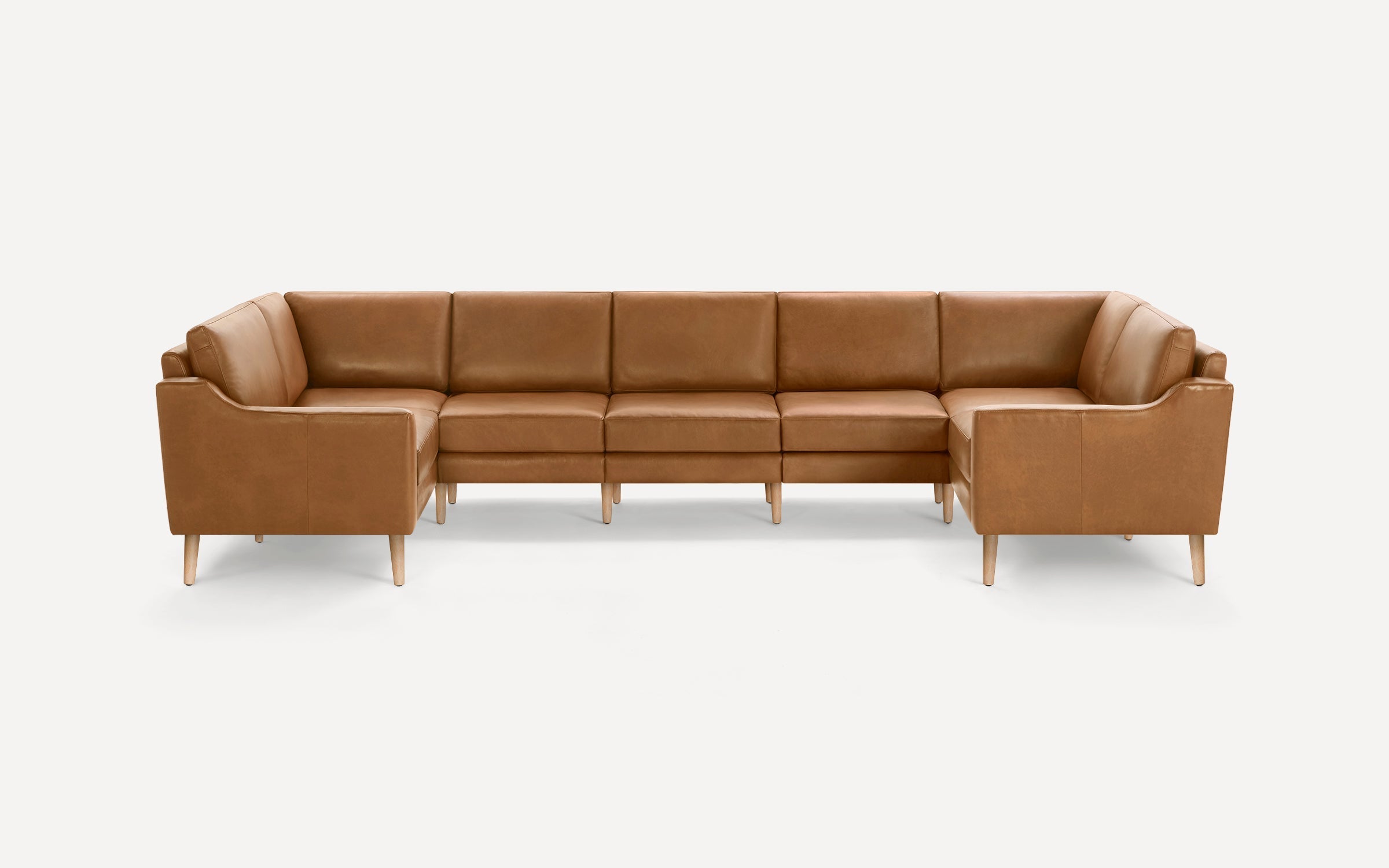 Brown leather sectional sofa with wooden legs, featuring clean lines and modern design, perfect for spacious living rooms.