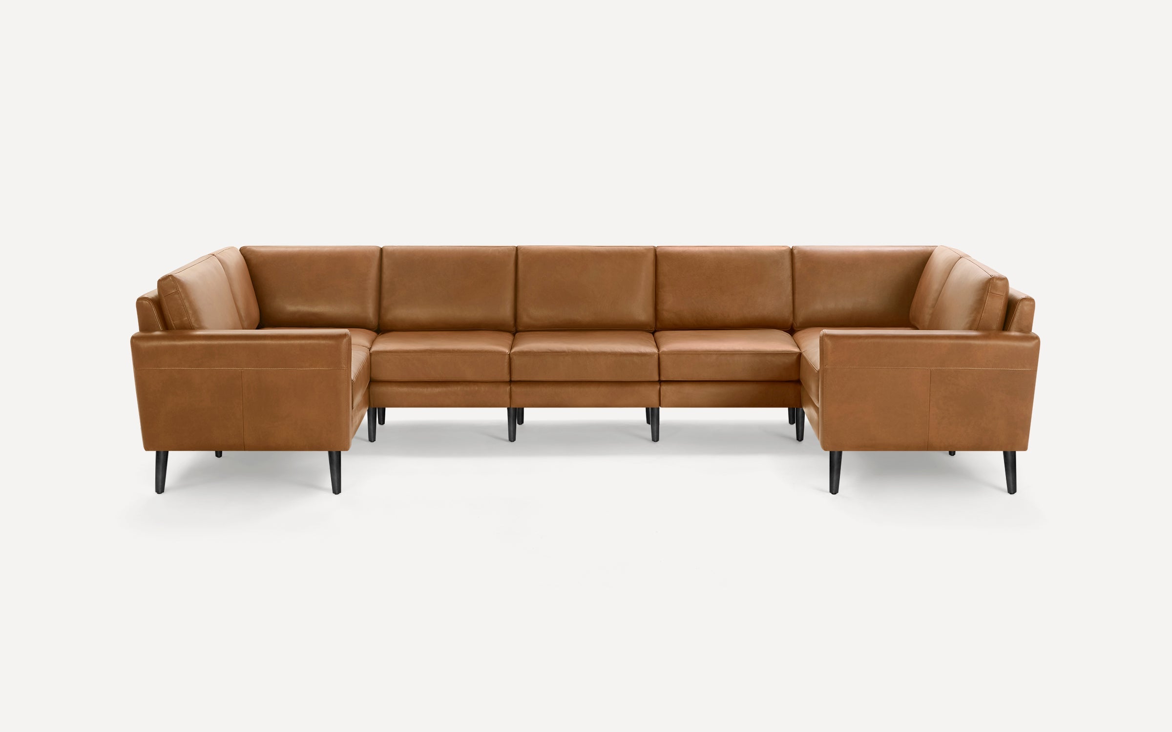 Modern U-shaped sectional sofa upholstered in smooth tan leather with clean lines and black tapered legs.