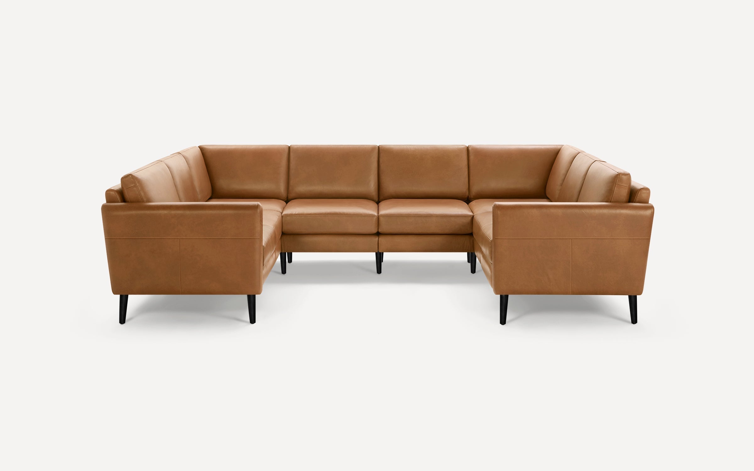 Modern L-shaped sectional sofa in tan leather with clean lines and black tapered legs on a white background.