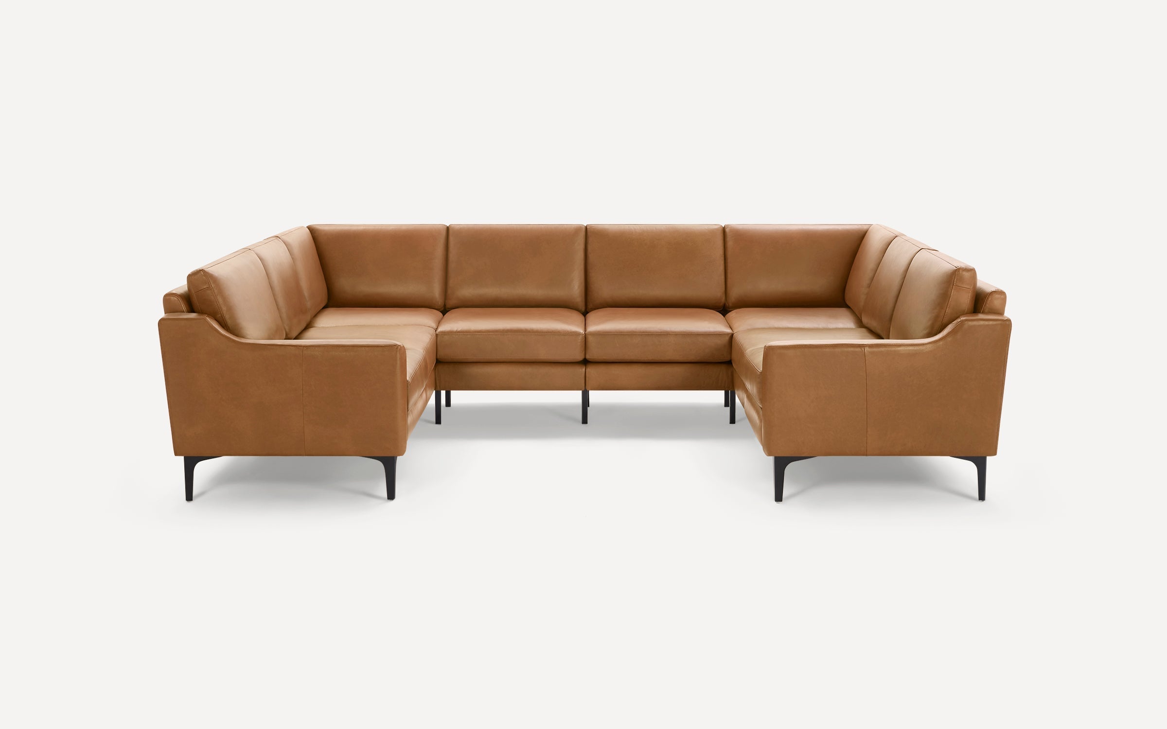 Modern U-shaped sectional sofa in tan leather with sleek black metal legs, featuring clean lines and plush cushions.