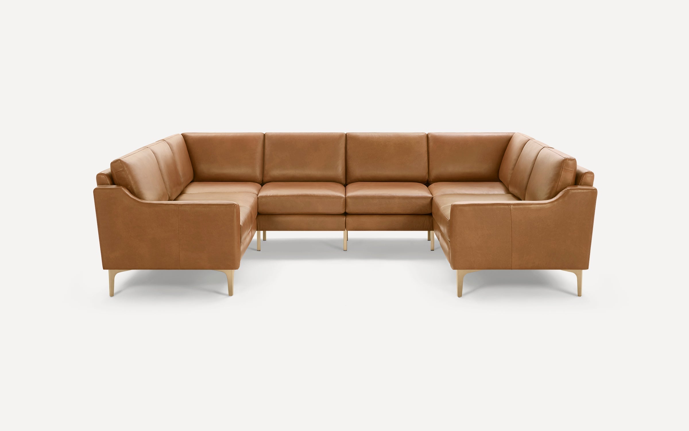 Modern U-shaped sectional sofa in tan leather with slim armrests and light wooden legs, set against a white background.