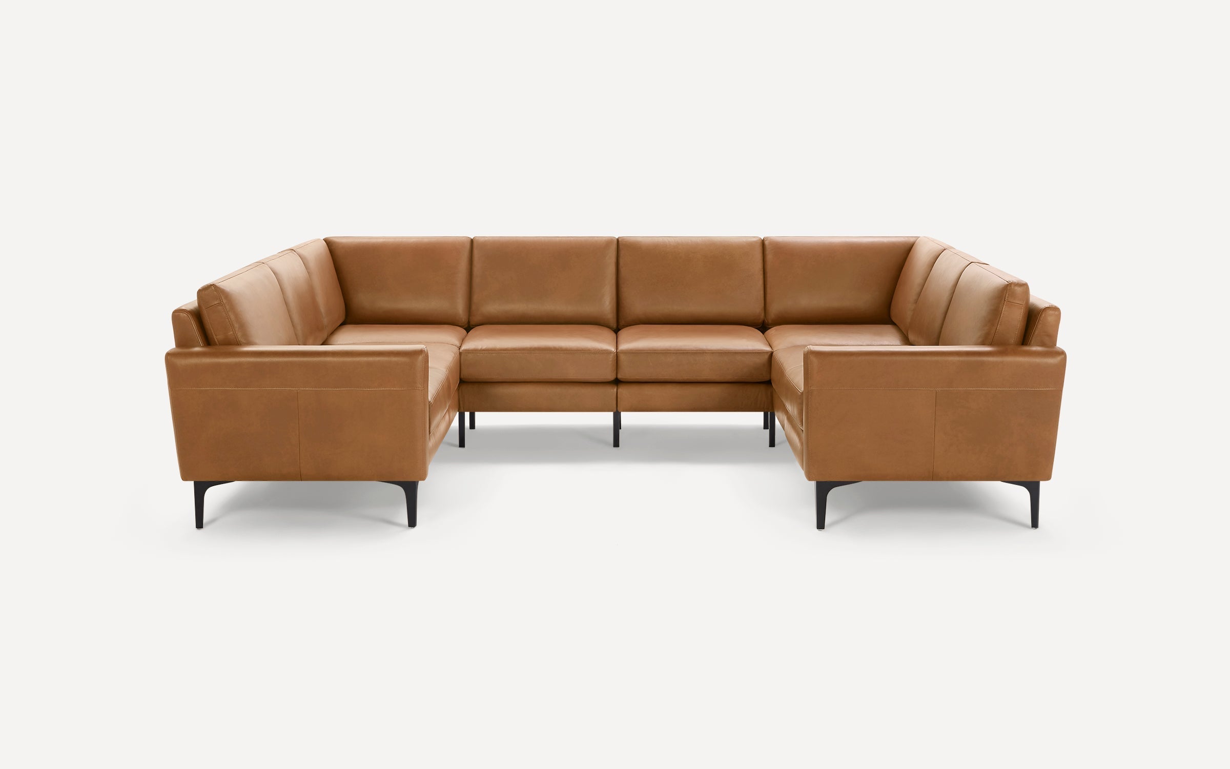 Modern U-shaped sectional sofa in tan leather with black tapered legs, offering spacious seating and clean lines.