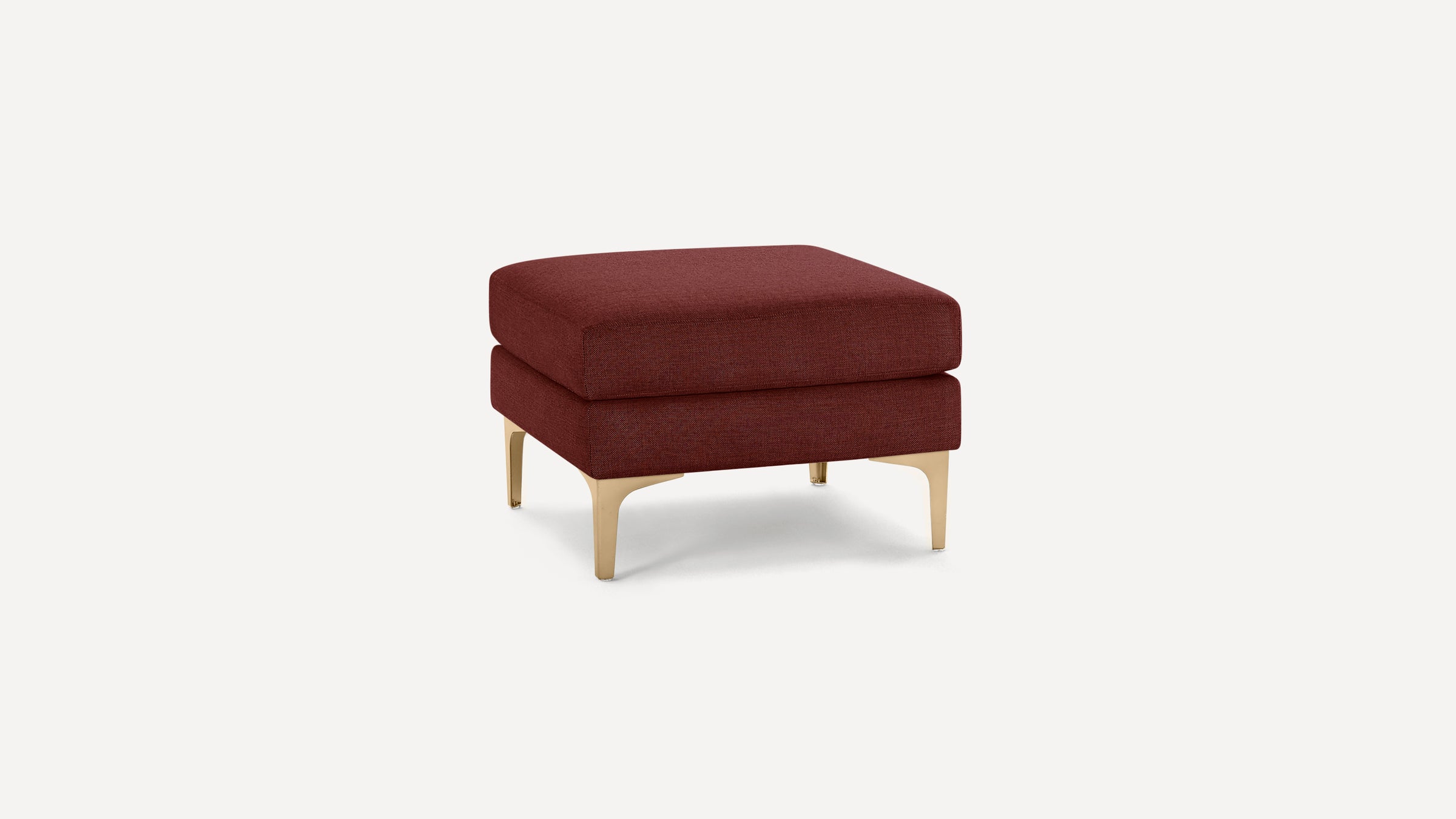 Square-shaped ottoman with plush burgundy fabric upholstery and sleek gold metal legs on a white background.