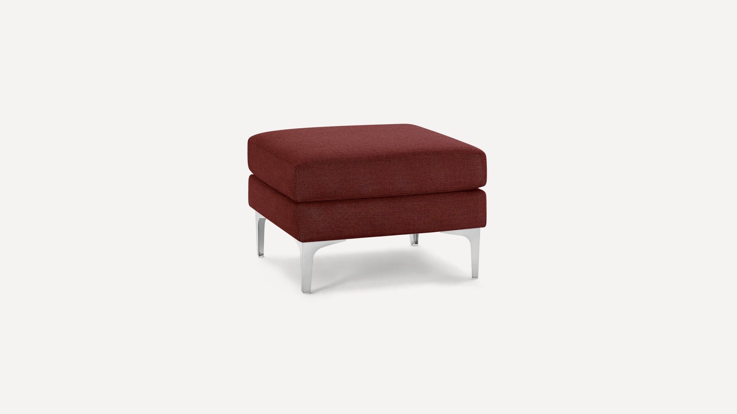Square modern ottoman with red fabric upholstery and sleek silver metal legs on a plain white background.