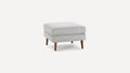 Modern square ottoman with light gray fabric upholstery and tapered wooden legs, minimalist design.