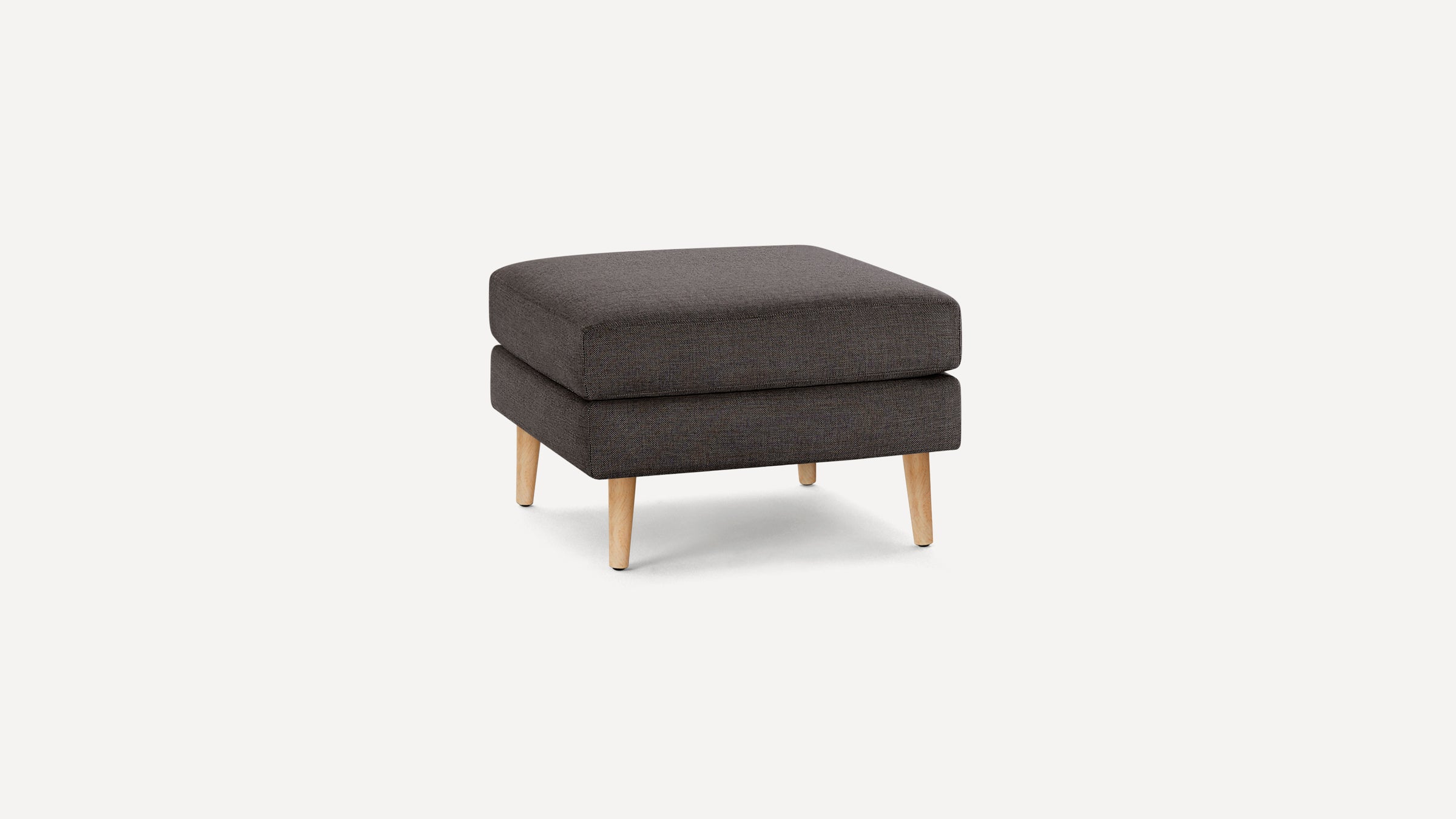Square dark gray upholstered ottoman with wooden tapered legs, modern and minimalist style.