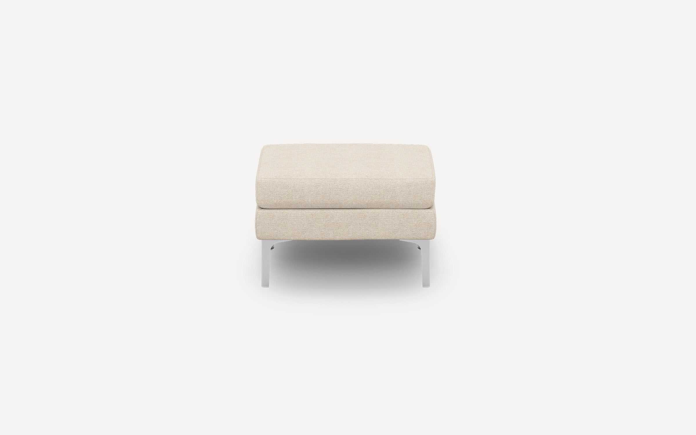 Beige fabric ottoman with clean lines and metal legs, shown from the front on white background.