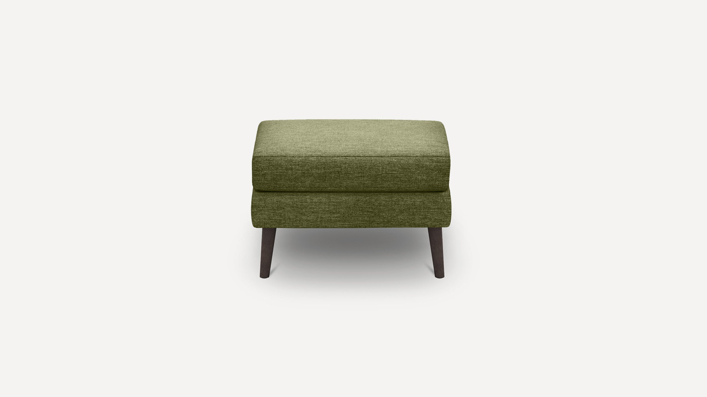 Green upholstered rectangular ottoman with tapered dark wooden legs on a white background.