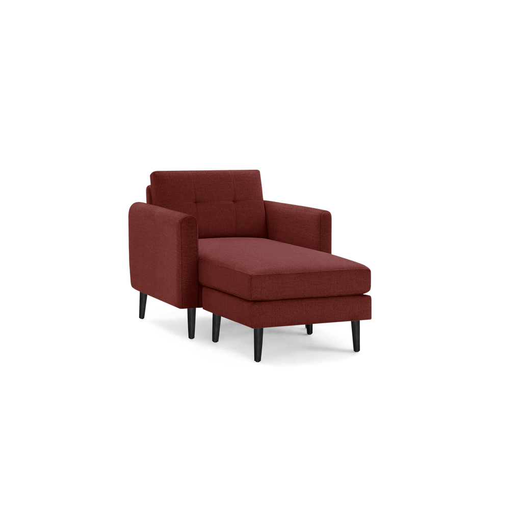 Modern chaise lounge upholstered in deep red fabric with tufted backrest and black tapered wooden legs.