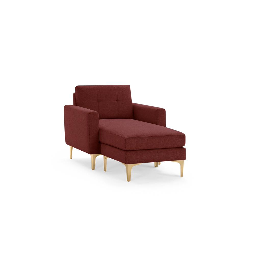 Modern deep red upholstered chaise lounge with tufted backrest, squared armrests, and light wooden tapered legs.