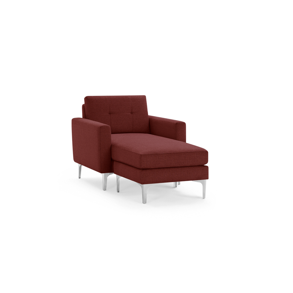Modern chaise lounge chair in deep red fabric upholstery with tufted backrest and sleek silver metal legs.