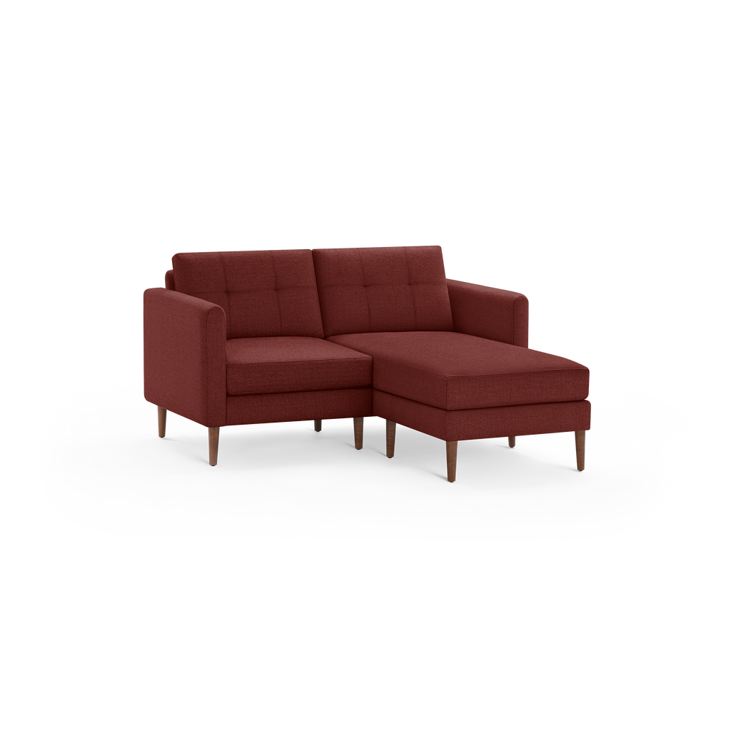 Mid-century modern style sectional sofa in dark red fabric with tufted cushions and wooden legs, featuring a chaise lounge on the right.