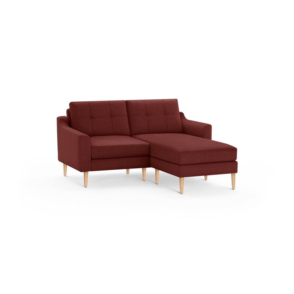 Modern L-shaped sectional sofa with tufted back cushions and wooden legs, upholstered in deep red fabric.