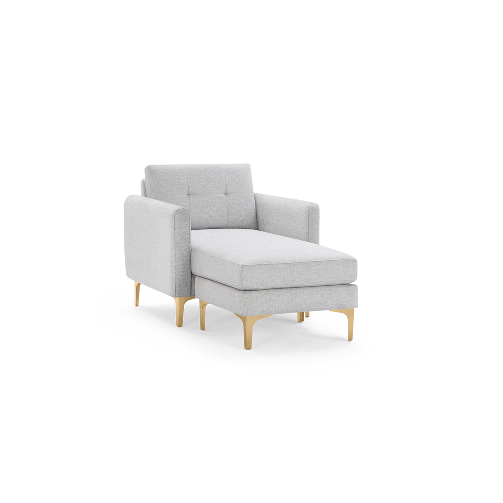 Light gray upholstered chaise lounge chair with tufted backrest and gold metal legs, combining comfort and modern style.