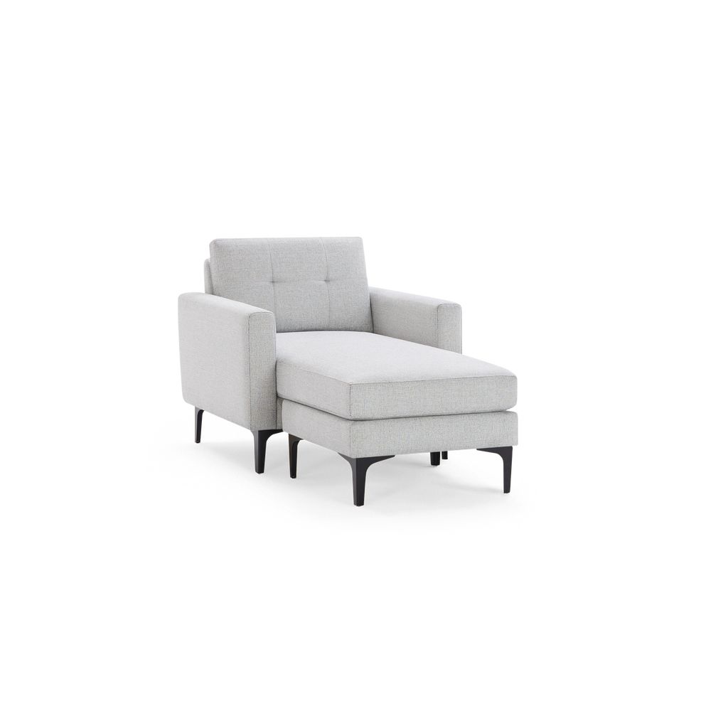 Modern light gray upholstered chaise lounge chair with tufted backrest, armrests, and black metal legs.