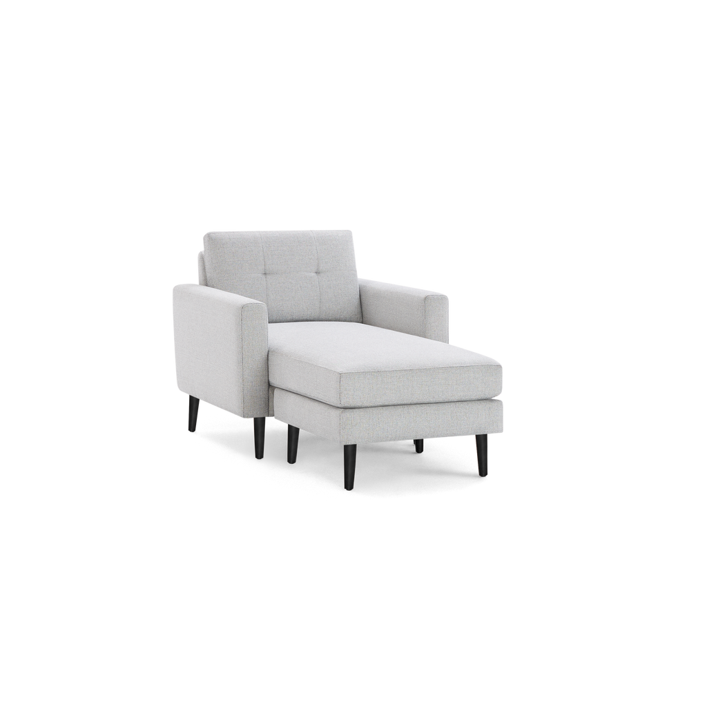 Light gray fabric chaise lounge chair with tufted backrest, straight armrests, and black tapered wooden legs.