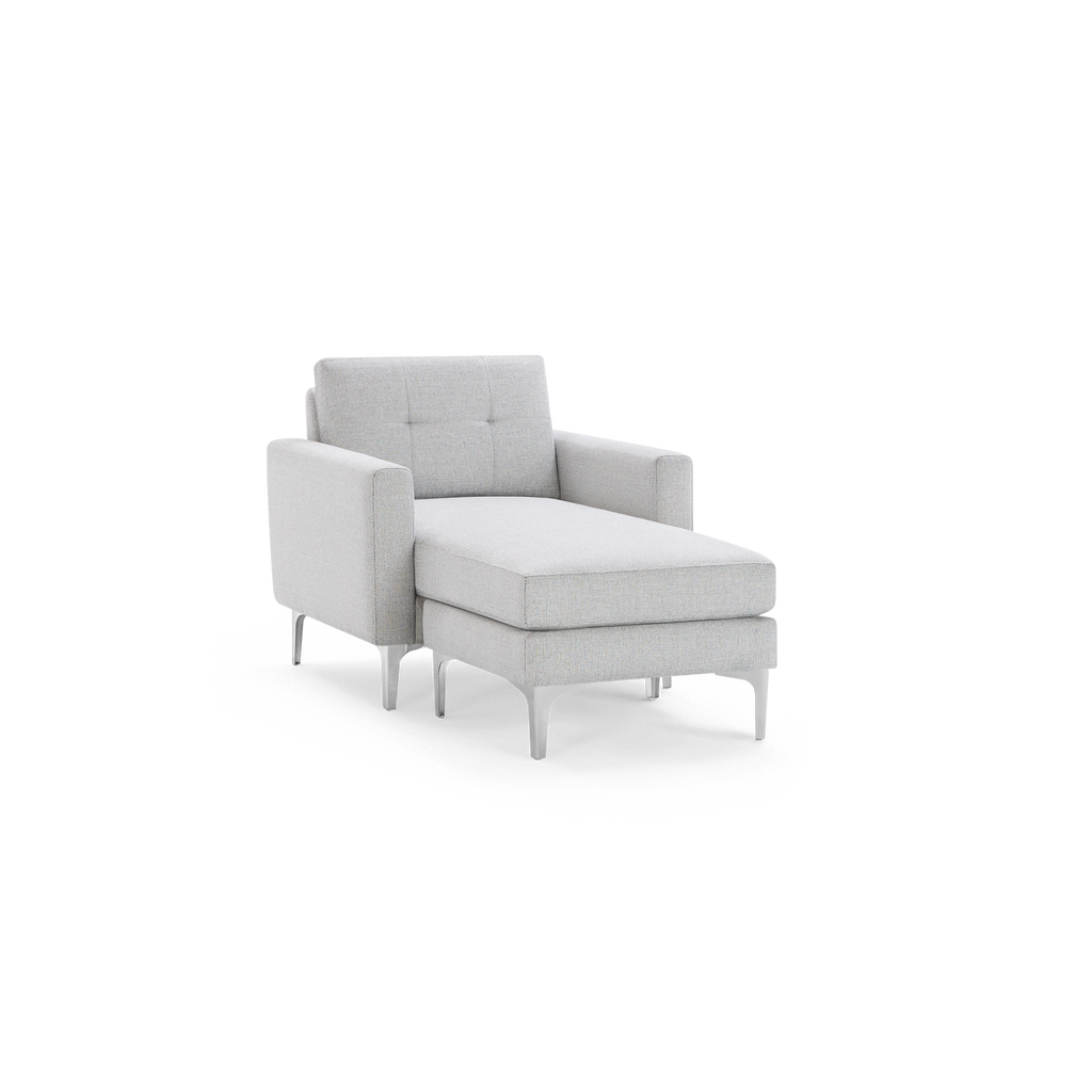 Light gray upholstered chaise lounge chair with tufted backrest, square armrests, and slim metal legs.