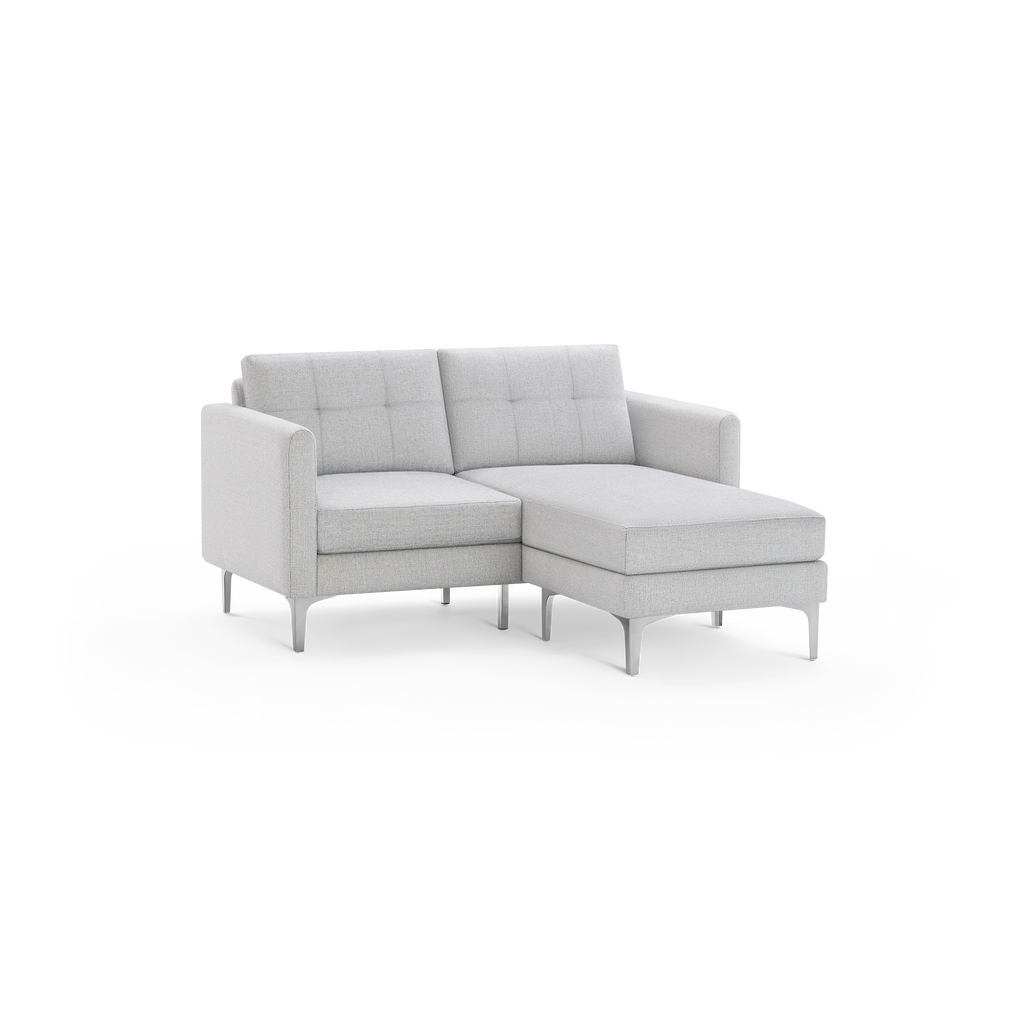 Light gray modern sectional sofa with tufted back cushions, metal legs, and an extended chaise lounge on the right side.