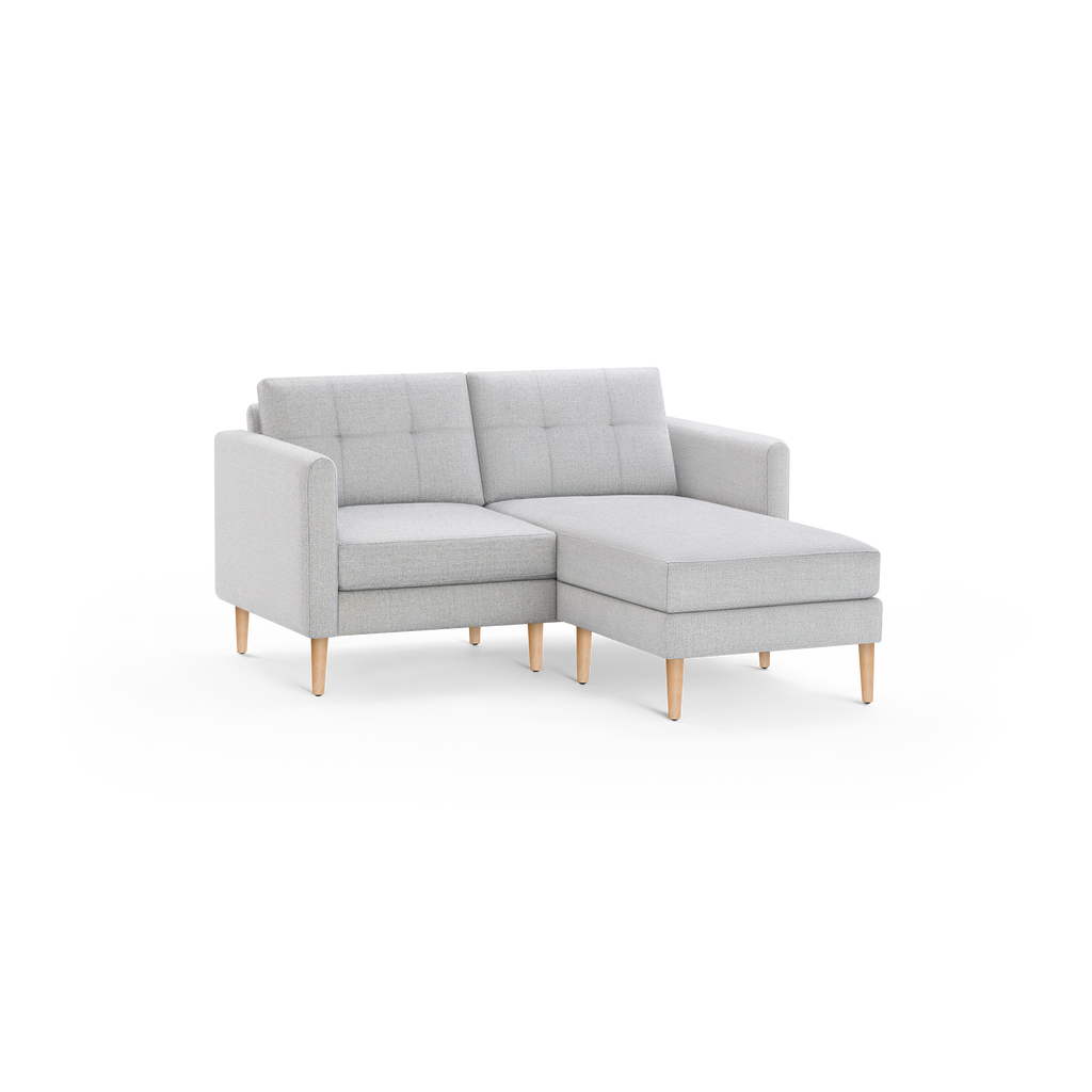 Light gray modern sectional sofa with tufted back cushions and wooden legs, featuring a right-side chaise lounge.