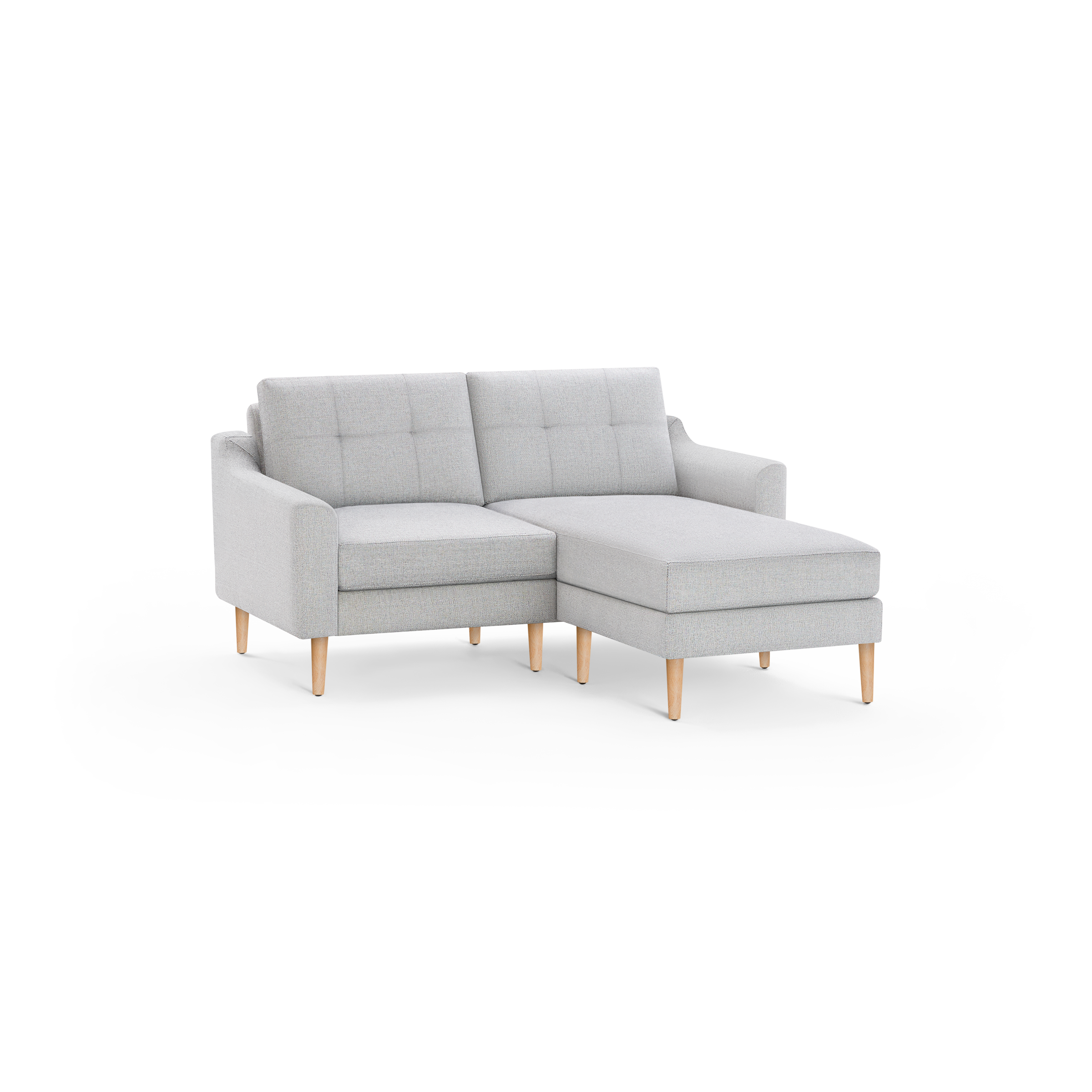 Light gray modern sectional sofa with tufted backrest, wooden legs, and a right-side chaise lounge, isolated on black background.