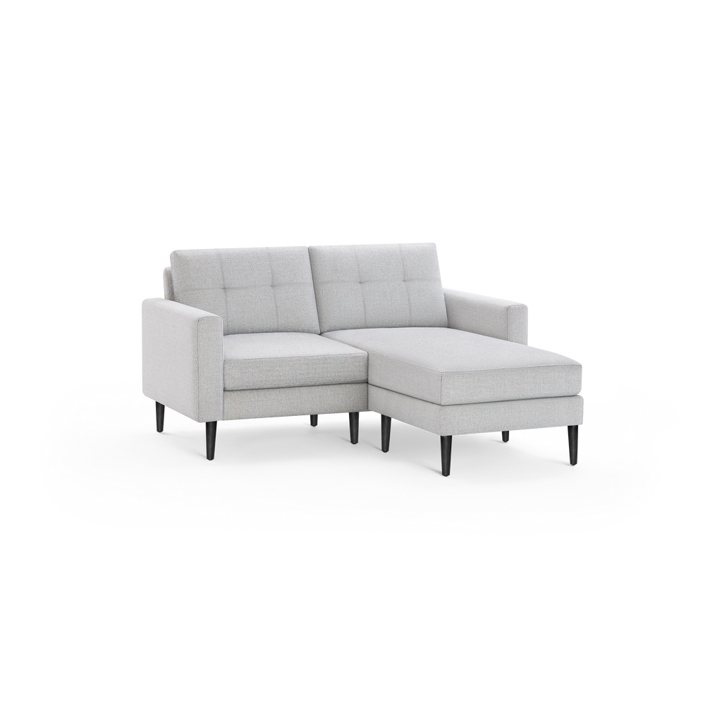 Light gray modern fabric chaise sectional sofa with tufted back cushions and dark tapered wooden legs, angled right.