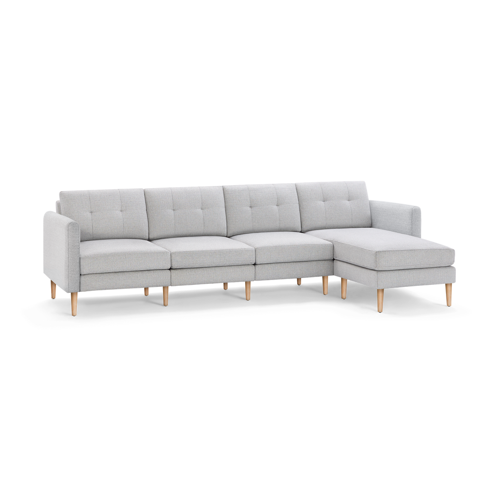 Light gray modern sectional sofa with tufted back cushions, wooden legs, and a right-side chaise lounge.