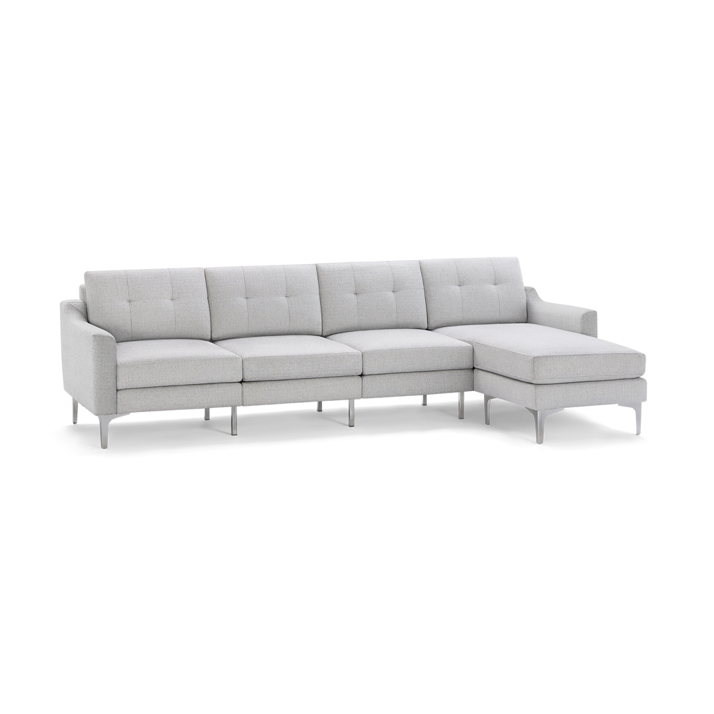 Light gray modern sectional sofa with tufted back cushions, metal legs, and a chaise lounge on the right side.