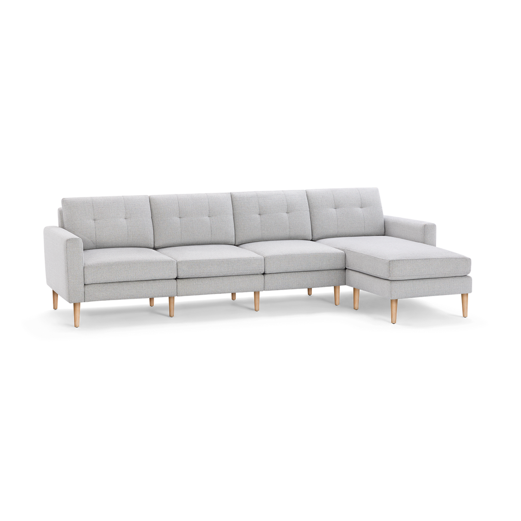 Light gray fabric sectional sofa with tufted back cushions, wooden legs, and right-side chaise lounge, modern design.