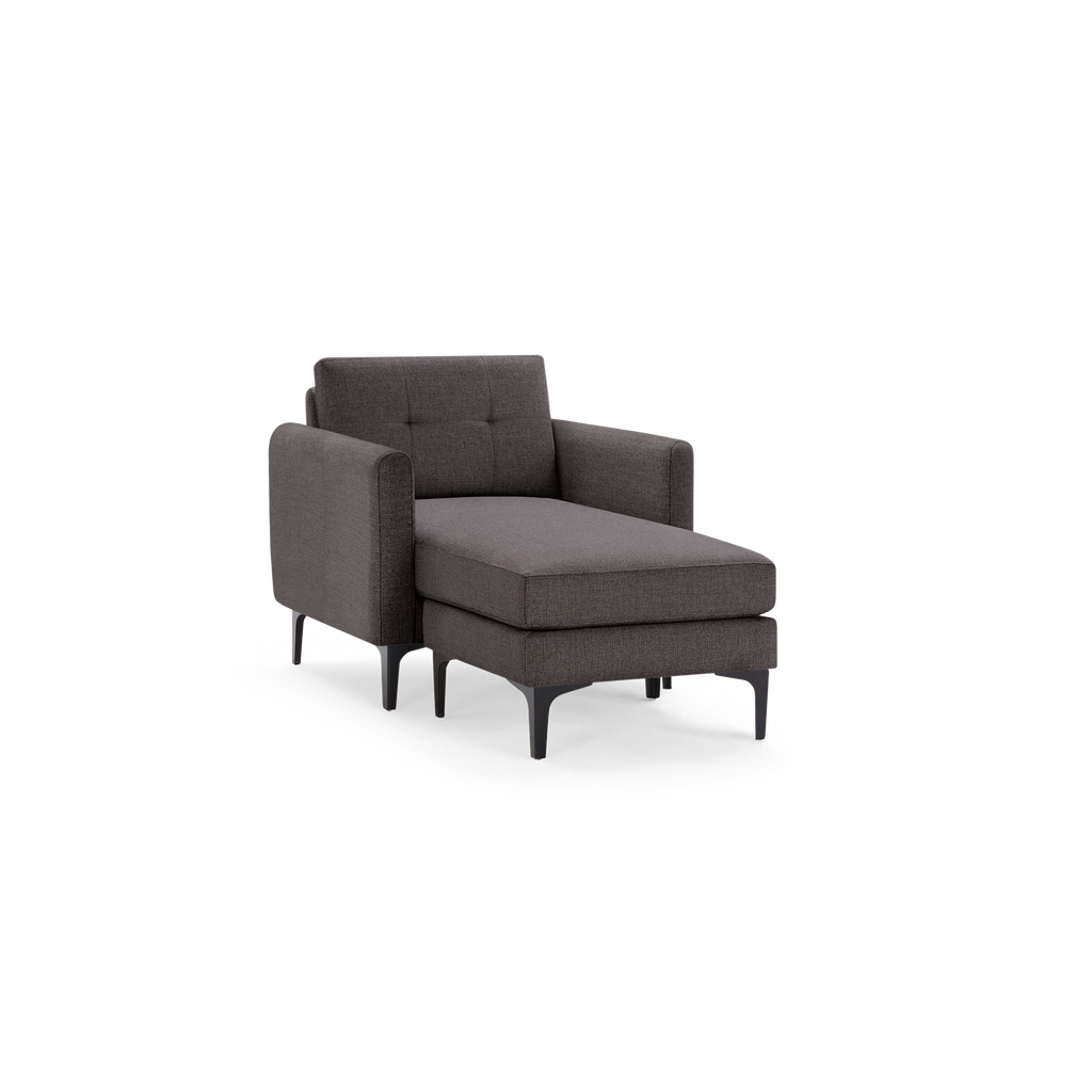 Dark gray upholstered chaise lounge chair with tufted backrest, armrests, and black angled metal legs.