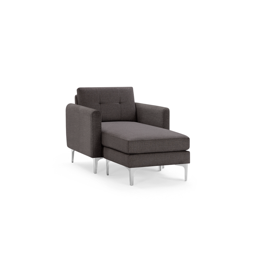 Modern dark gray fabric chaise lounge chair with tufted backrest, cushioned seat, armrests, and sleek silver metal legs.