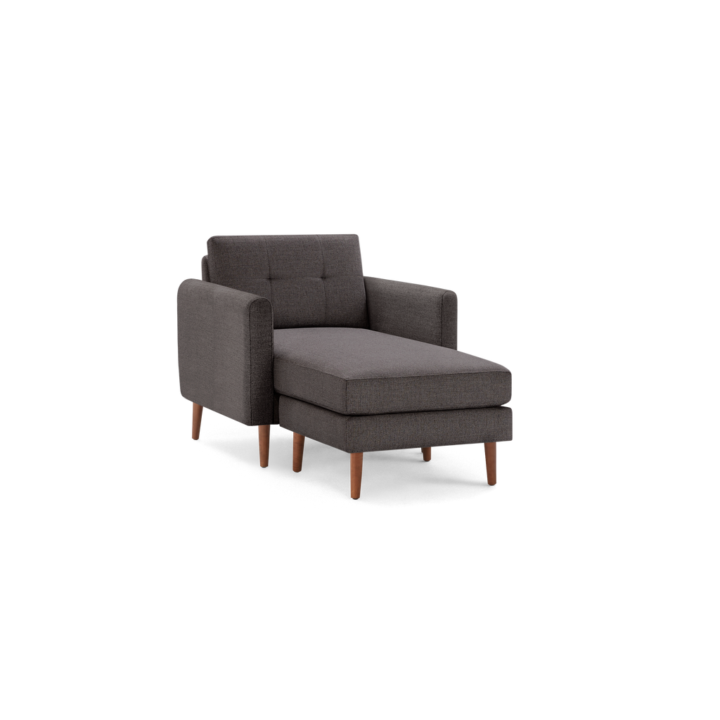 Modern dark gray chaise lounge chair with tufted backrest and wooden legs, designed for comfortable seating and relaxation.