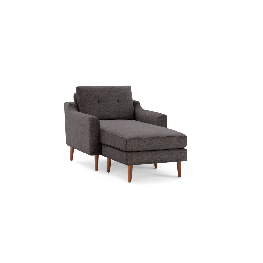 Modern dark gray fabric chaise lounge chair with tufted backrest and wooden legs, shown on a white background.